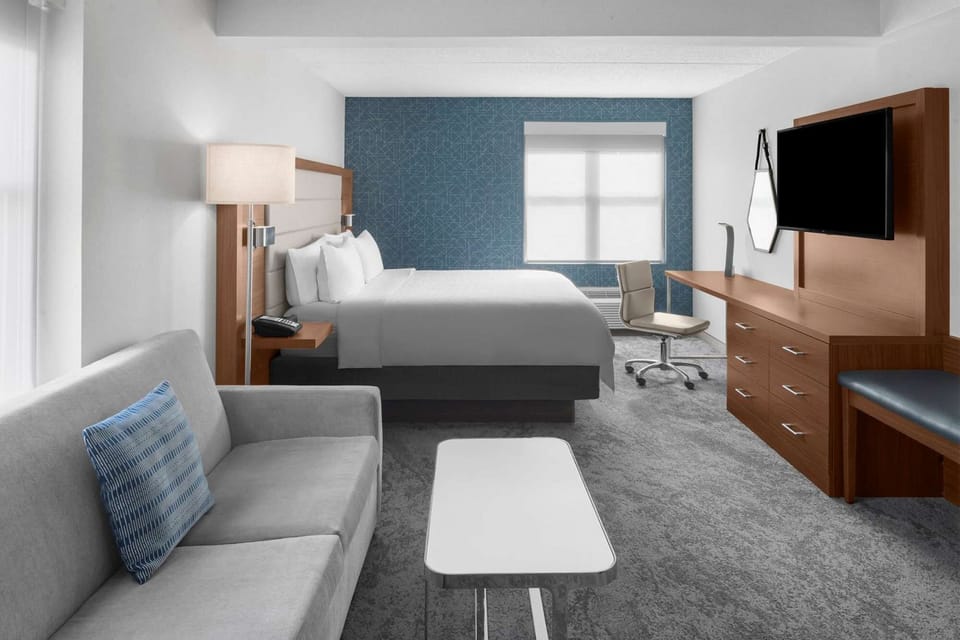 King bed room with sofa, desk, TV, and open floor space