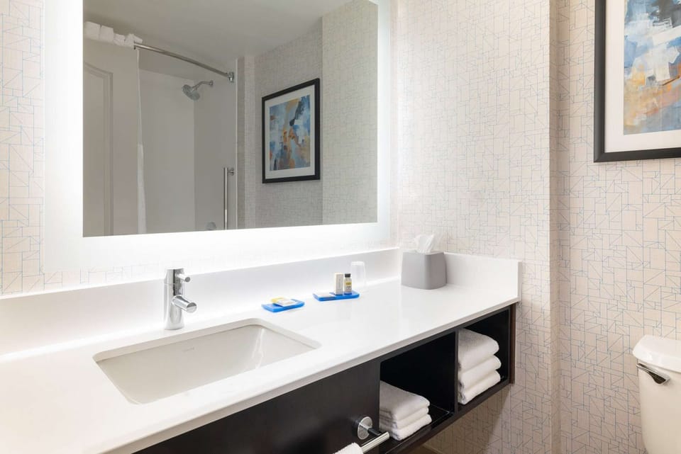 Bathroom with wide sink, mirror lighting, and fresh towels
