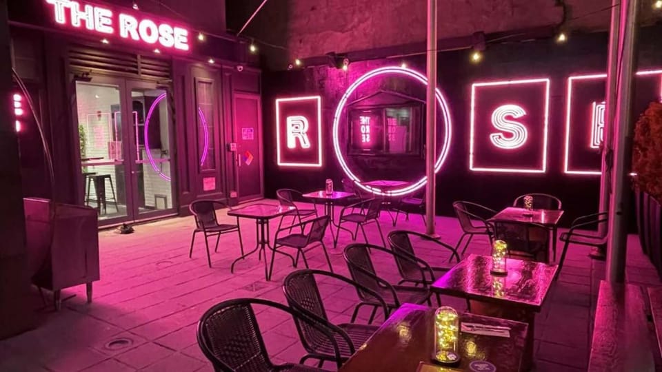 Outdoor bar patio with neon rose and string lights