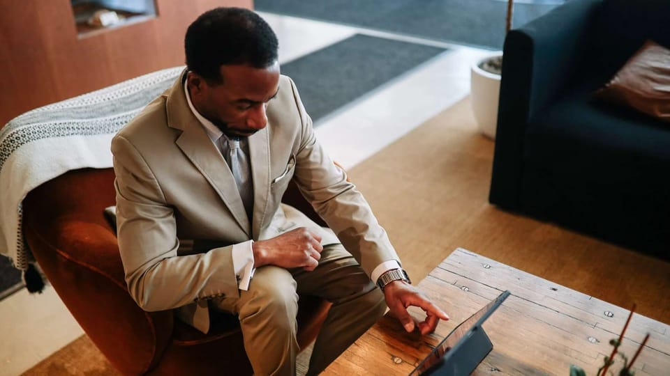 Man in suit using a tablet in a lounge setting