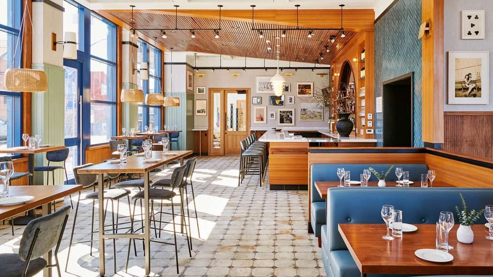 Dining room with wood ceiling, bar seating, and set tables