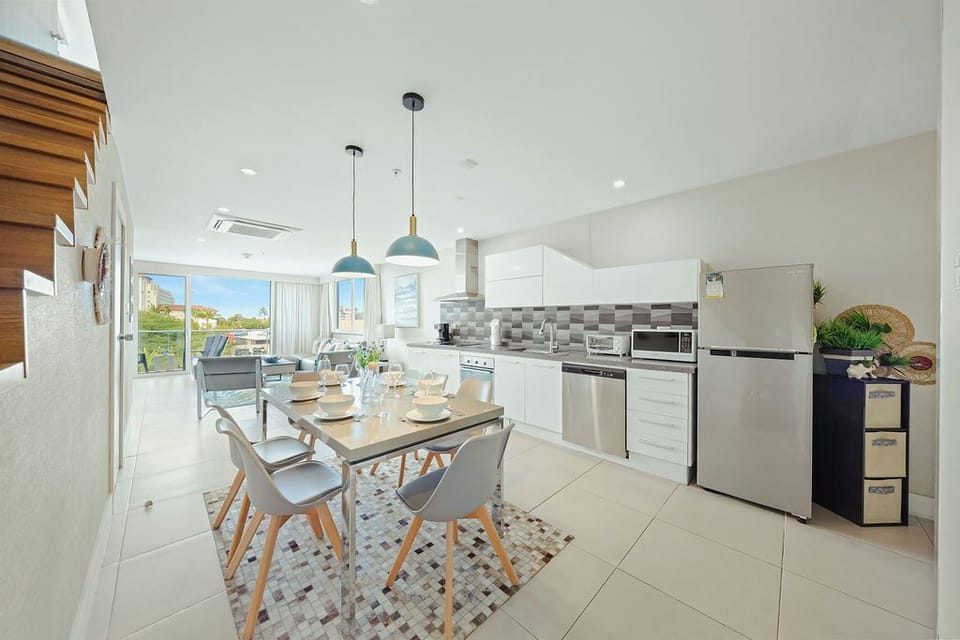 Your modern kitchen features stainless steel appliances, sleek pendant lighting, and a stylish dining table where you'll enjoy meals with views.