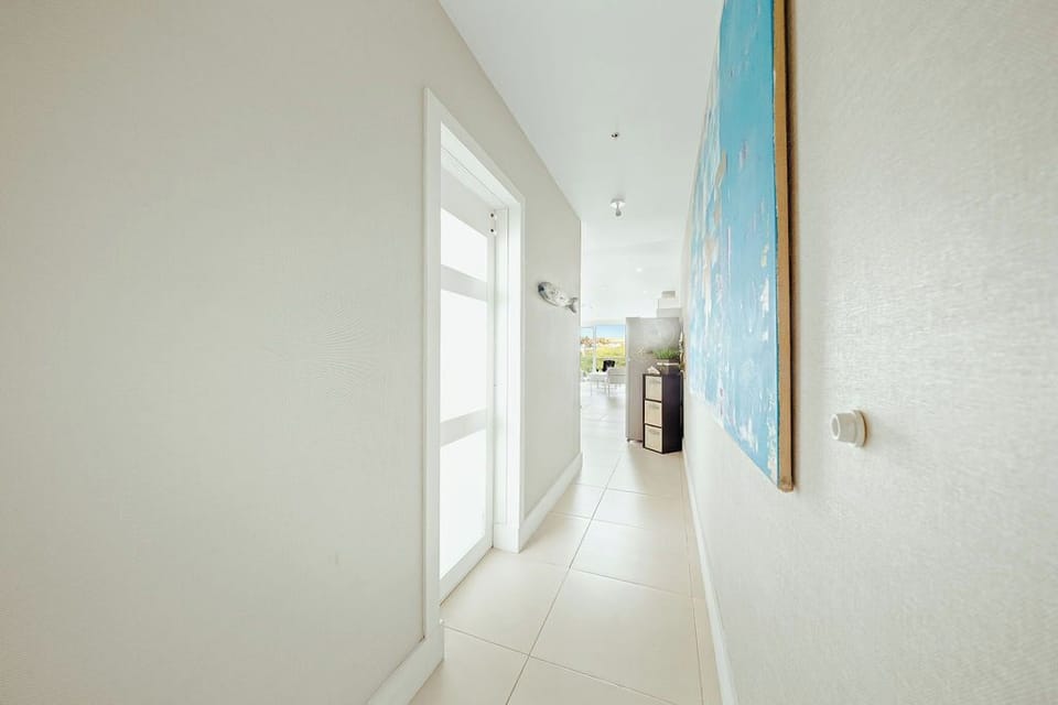 Bright hallway with elegant artwork guides you to your comfortable spaces.