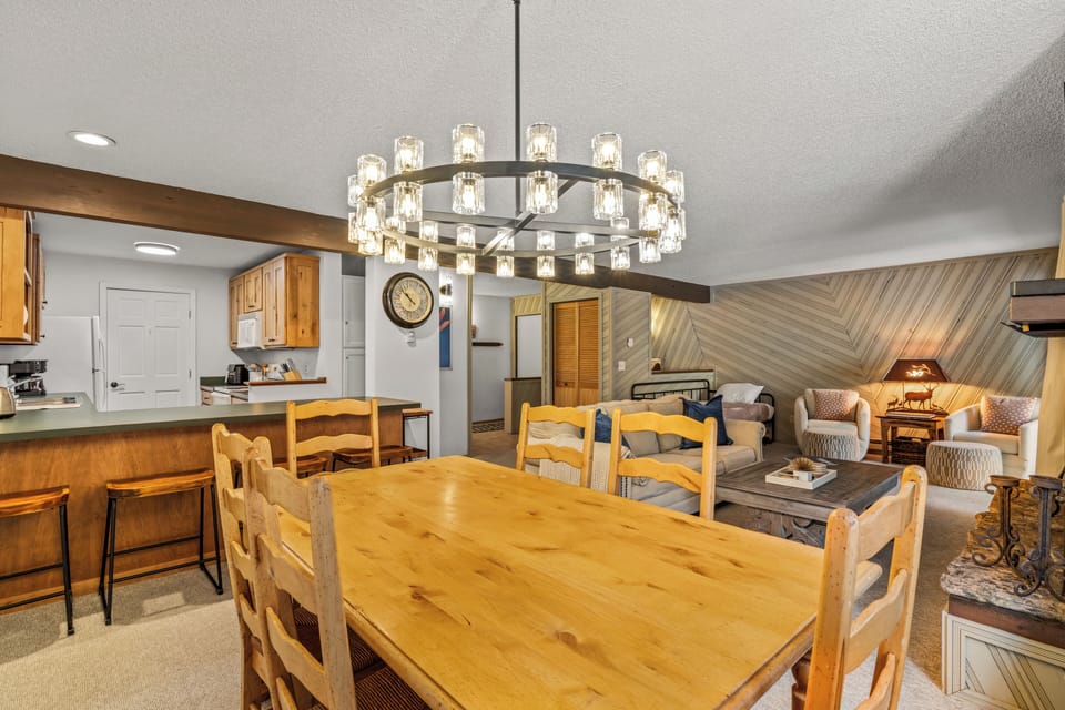 Gather around your spacious dining table under elegant chandelier lighting, with the cozy living area just steps away for post-meal relaxation.