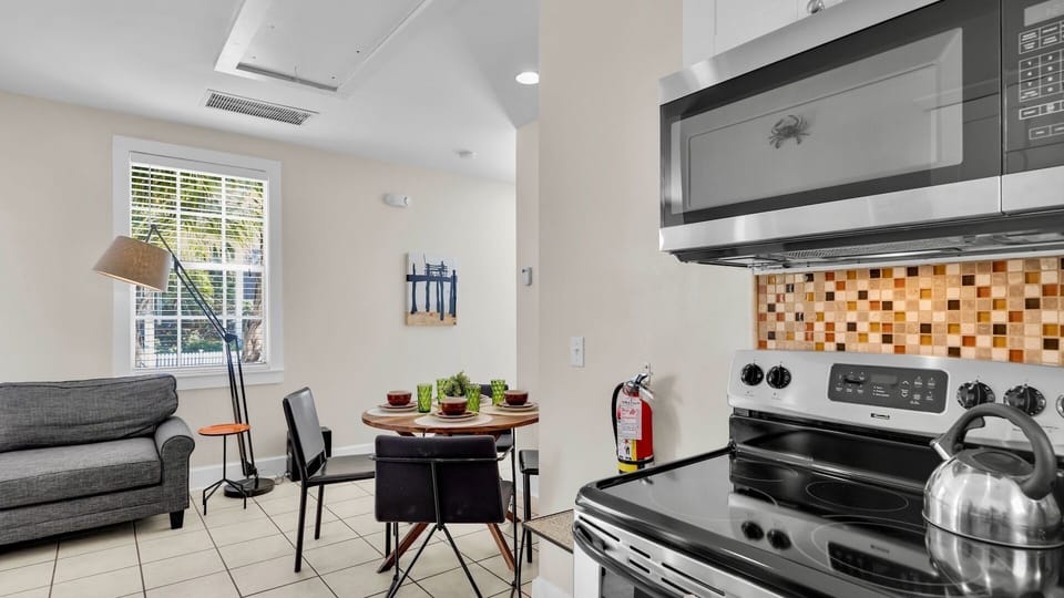 Your modern kitchen features sleek appliances, warm mosaic backsplash, and cozy dining nook perfect for morning coffee or intimate meals.