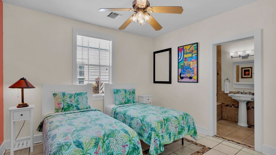 Relax in your bright twin bedroom featuring tropical bedding and a private ensuite bathroom with convenient access.