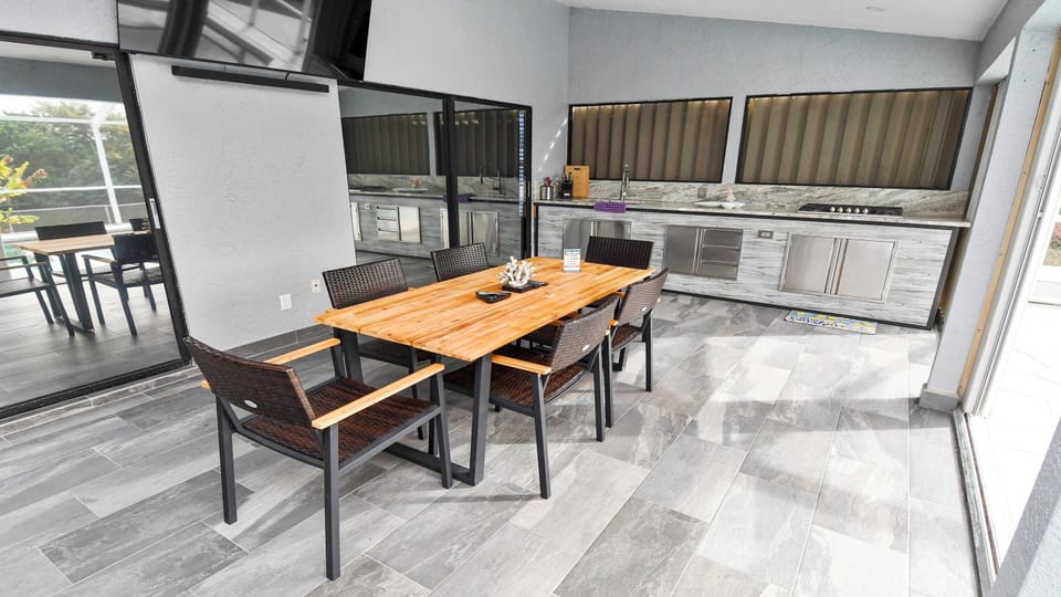 Large covered terrace with outdoor kitchen and dining area invites you to enjoy meals together 