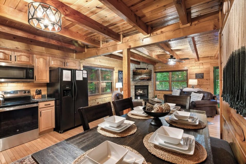 Gather around your rustic dining table while the fireplace crackles nearby, creating the perfect cabin atmosphere for memorable meals together.