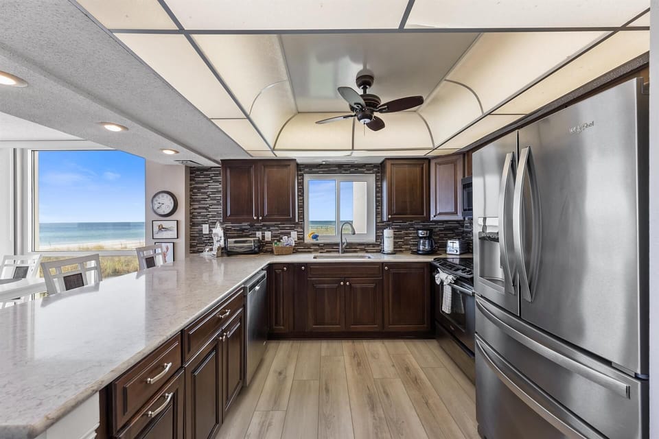 Your fully equipped kitchen offers granite counters and ocean views, perfect for preparing meals while watching the waves.