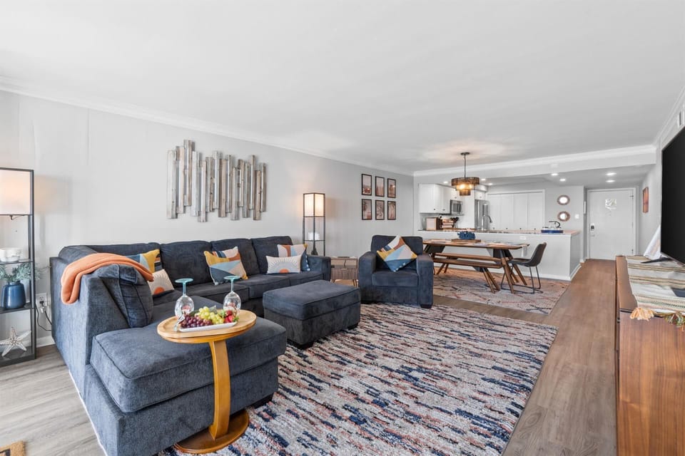 Sink into this spacious open-concept living area where comfort meets style. Your sectional sofa and colorful accents create the perfect gathering spot.