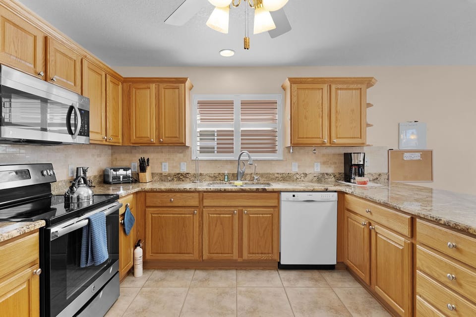 Your fully equipped kitchen invites home-cooked meals with granite counters, modern appliances, and warm wood cabinets creating the perfect culinary retreat.