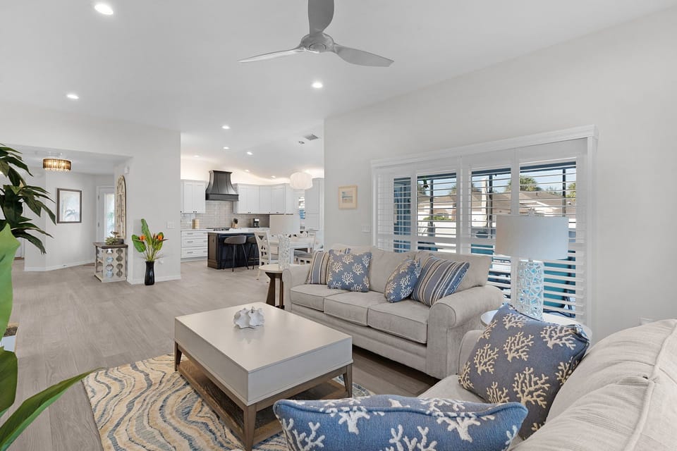 Unwind in your spacious open-plan living area, where coastal blues and whites create a serene atmosphere perfect for relaxation.