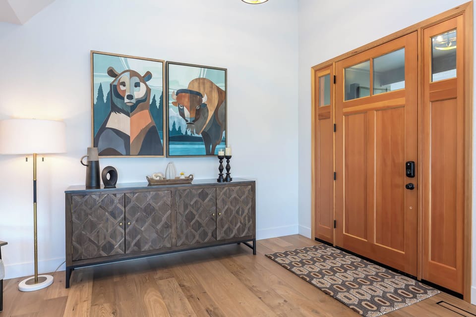 Step into your welcoming entryway featuring warm wood floors, stylish furniture, and charming wildlife artwork that sets a cozy tone for your stay.