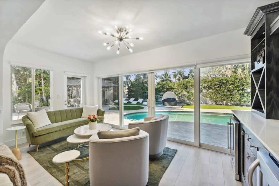 Stylish secondary living area featuring comfortable seating and large glass doors that open to relaxing pool and backyard views.