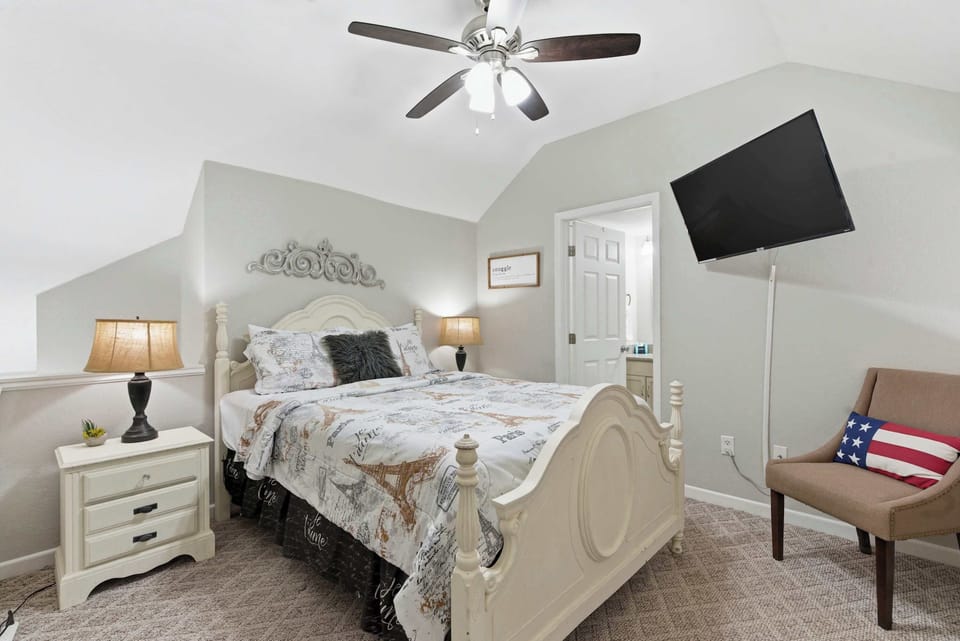 The loft bedroom showcases a plush queen bed, smart TV, & ensuite bath​