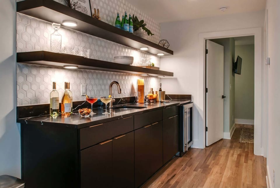 Wet bar with wine fridge stocked and ready for karaoke breaks, tucked beside the stage so drinks flow between songs without missing a beat