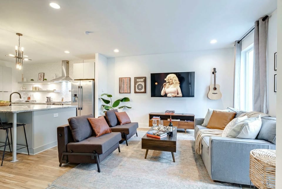 Open-concept living room and kitchen let the whole group scatter across the sofas while the cook stays in the action, all under one ceiling