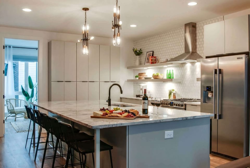 Marble island sized for a crowd: this is where the group breakfast happens before everyone splits for exploring Centennial Park and beyond. Reserve your Nashville getaway with Misfit Homes