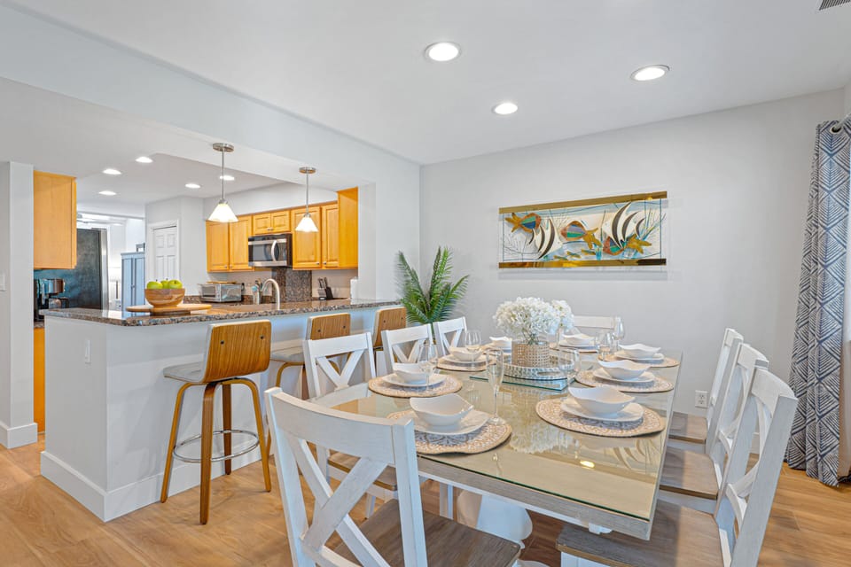 A fresh, open dining space with seating for the whole group, natural light throughout, and sliding doors that lead directly to the balcony.