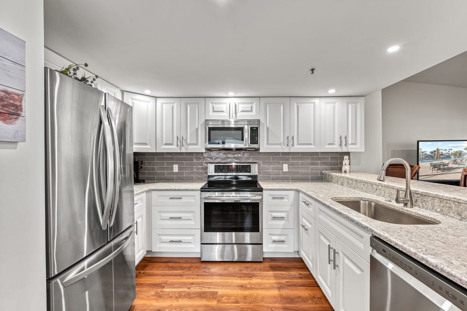 Step into the kitchen, filled with sleek stainless steel appliances.
