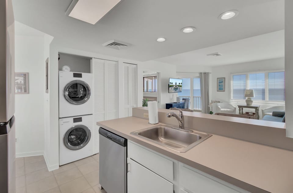 Kitchen area showing the integrated stacked washer and dryer unit and dishwasher.