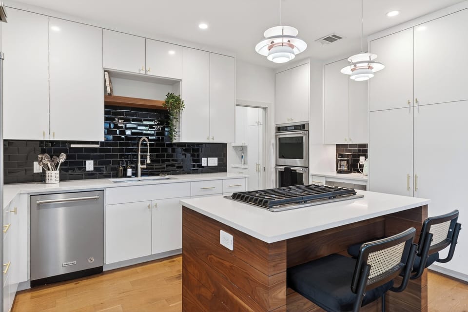 Sleek chef’s kitchen with a spacious island, modern appliances, and stylish pendant lighting.