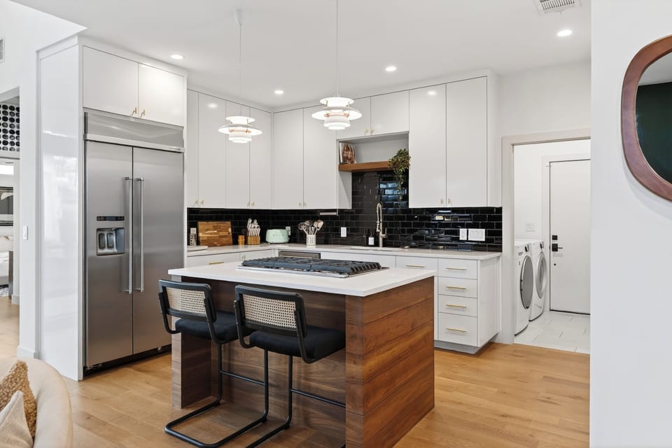 Sleek, modern kitchen with a spacious island, stainless steel appliances, and bar seating for casual meals.