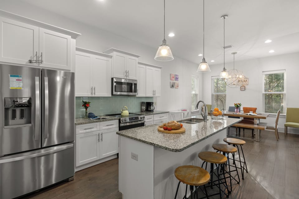 Modern, open-concept kitchen with stainless steel appliances and a spacious island with seating.