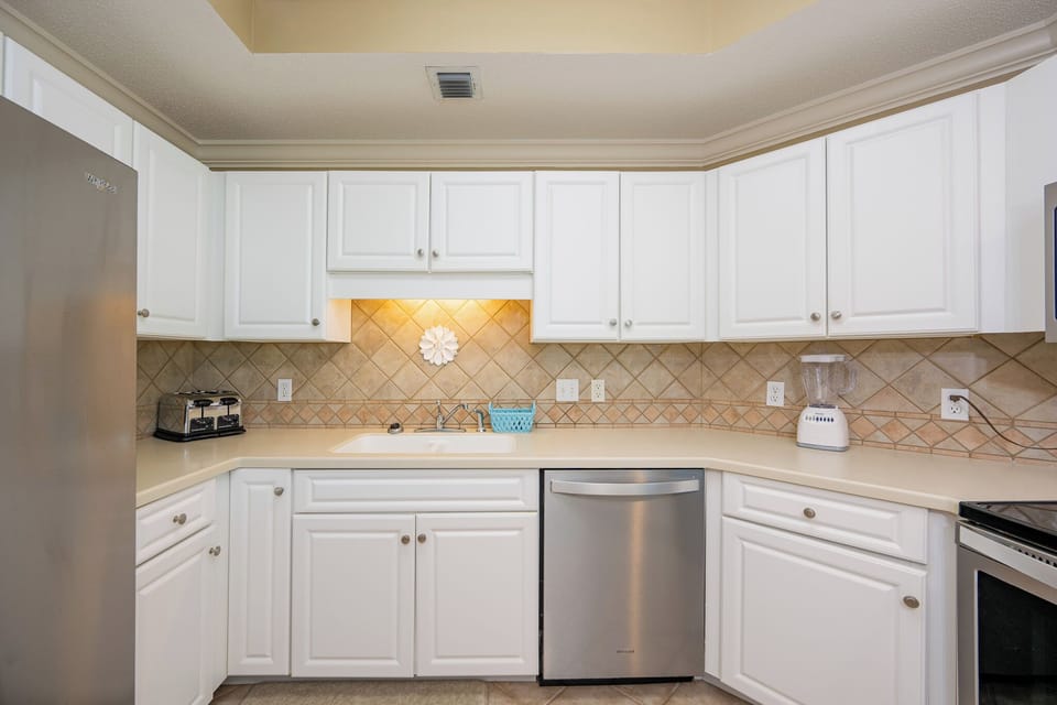 Prepare meals in this kitchen with sleek cabinetry, stainless appliances, and spacious countertops
