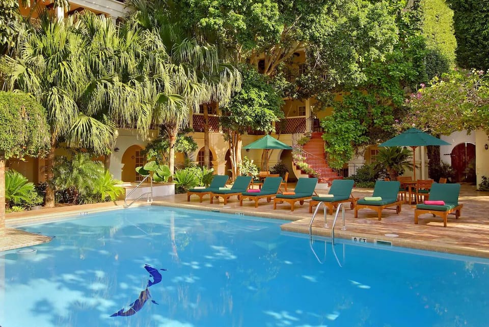 Unwind poolside beneath palms in a serene courtyard oasis.
