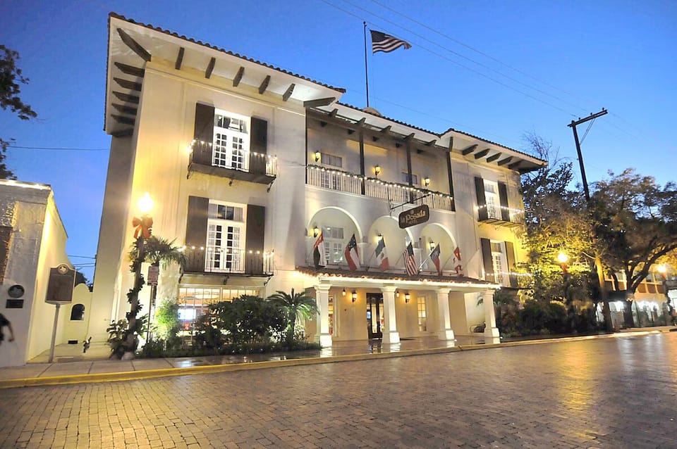 Arrive to a grand, warmly lit façade at dusk.