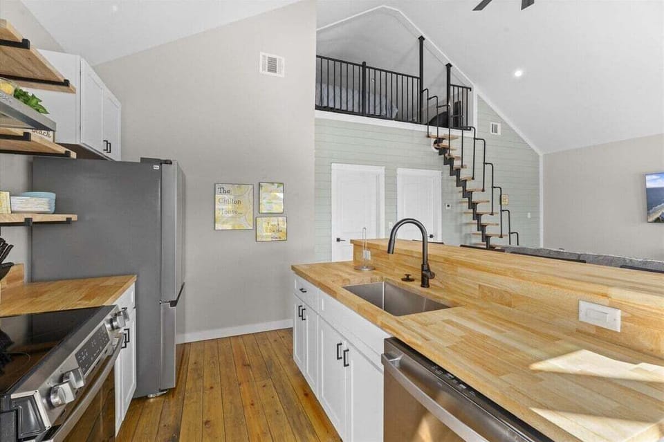 Modern kitchen with butcher block countertops, stainless steel appliances, and spacious open-concept design.