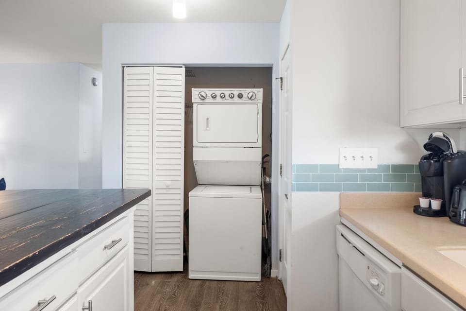 Your in-unit washer and dryer make extended stays effortless, tucked behind stylish louvered doors in this modern kitchen space.