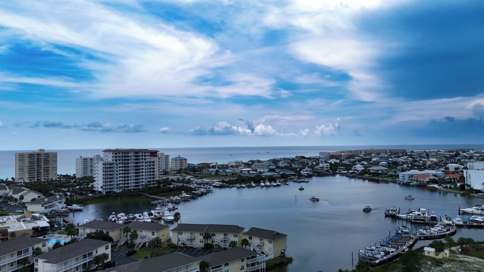 Stunning aerial view of our waterfront community with marina and condos along the peaceful Destin harbor
