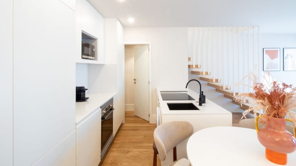 Modern kitchen with integrated appliances and a sleek island, flowing seamlessly into the open-concept dining area.
#OpenKitchen #ScandinavianStyle #PortoDuplex #FunctionalDesign