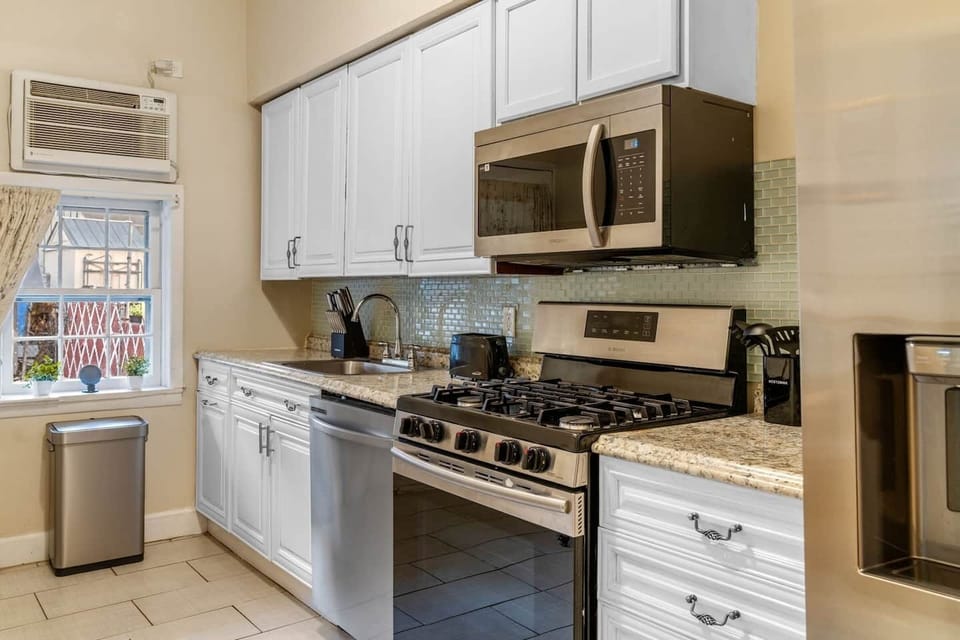 Modern gas stove, microwave, dishwasher, and a complete set of cookware and utensils make meal prep simple and efficient.