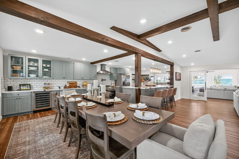 Open-plan kitchen & dining with beams, island seating, and water views