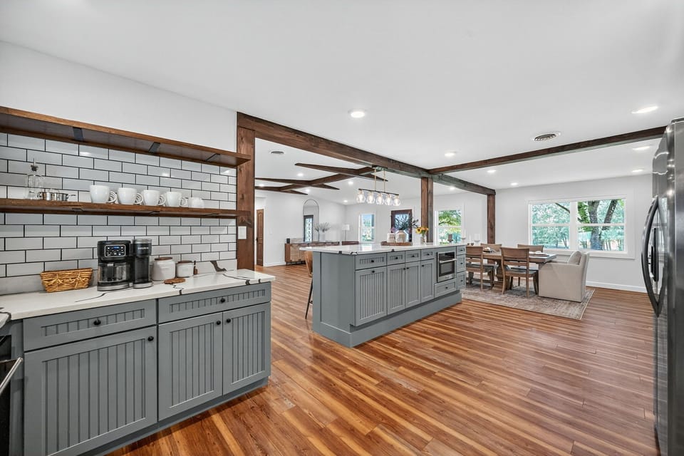 Bright open kitchen with island, beams, and dining—great for entertaining.