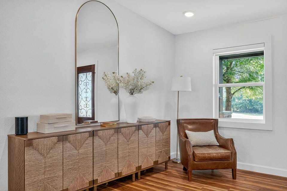 Sunny entry nook with leather lounge, arched mirror and textured credenza