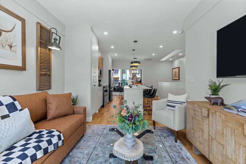 Spacious living area with cozy seating, mountain view, and a large TV, perfect for relaxation.