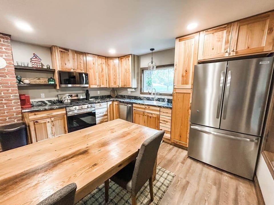 Enjoy modern appliances, generous counter space, and hickory wood cabinetry in this charming heart-of-the-home.