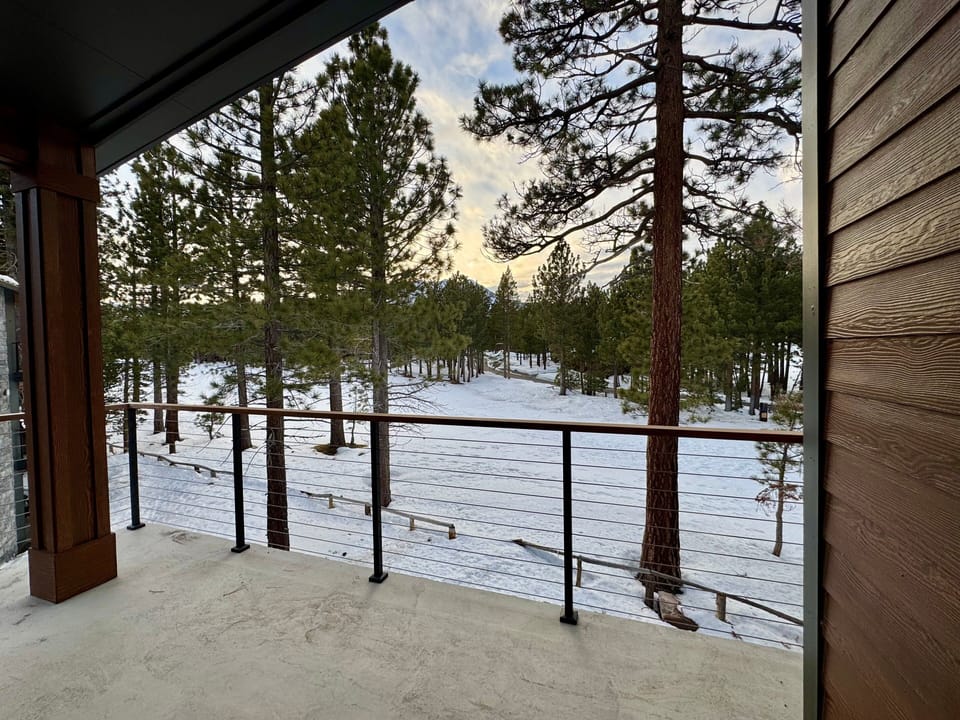 Private deck off primary bedroom w/ forest views.