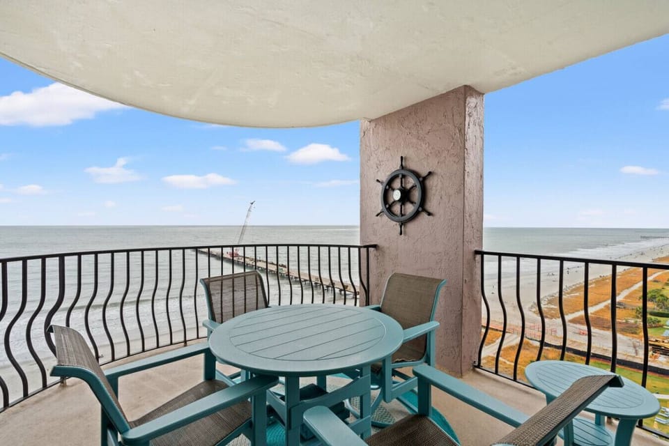 Oceanfront balcony dining table with seating for four, perfect for enjoying meals, morning coffee, or sunset views with the sound of the waves below.