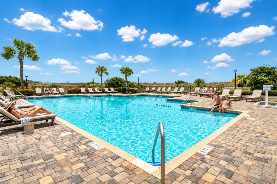 Beautiful Ocean Creek beachside pool with sparkling water, spacious sun deck, comfortable loungers, and relaxing coastal views just steps from the beach.