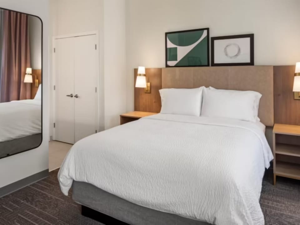 Unwind in crisp linens and a serene, modern bedroom.