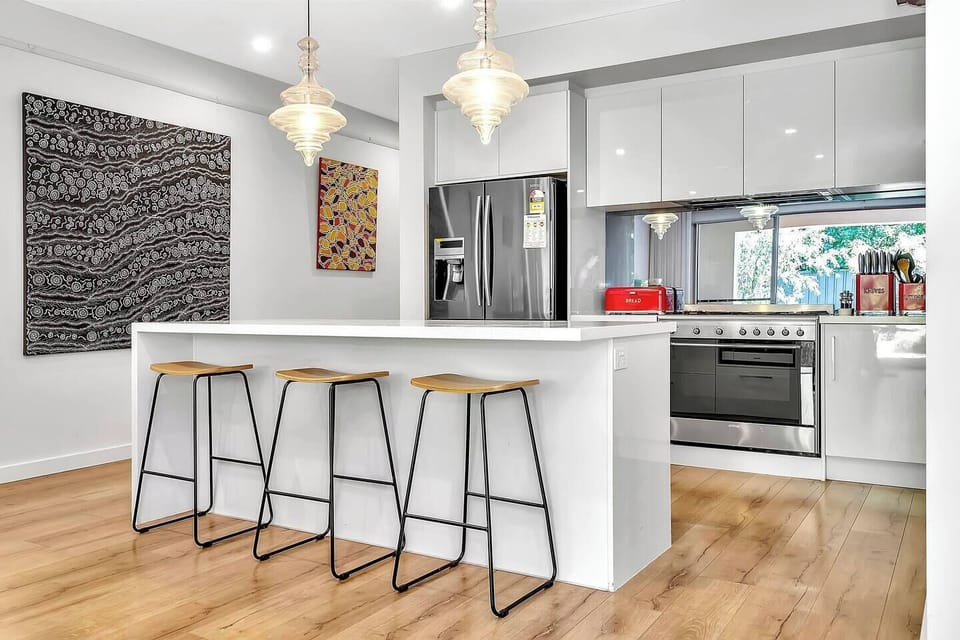 Modern kitchen with breakfast bar and red retro appliances.