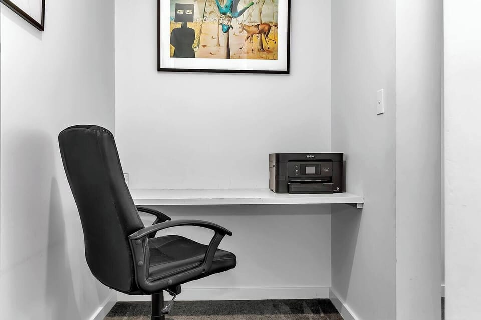 Dedicated workspace equipped with a desk, ergonomic chair, and printer.