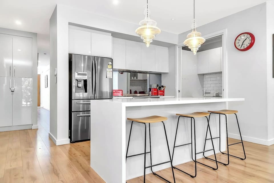 Large stainless steel fridge and ample pantry storage.