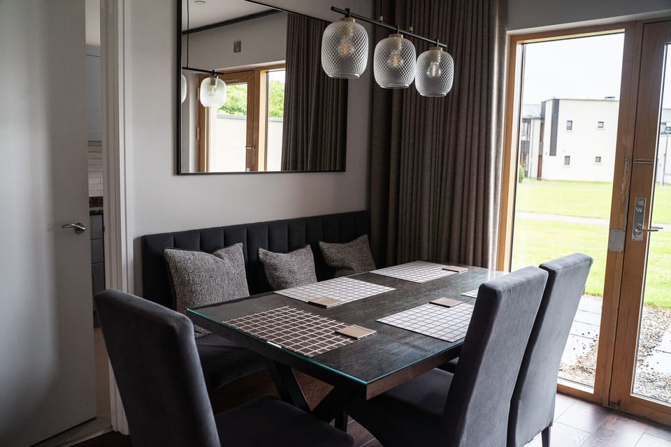 Johnstown Estate Holiday Lodges. Self catering lodge Co Meath. Dining table with view to green, Patio door. Bright.