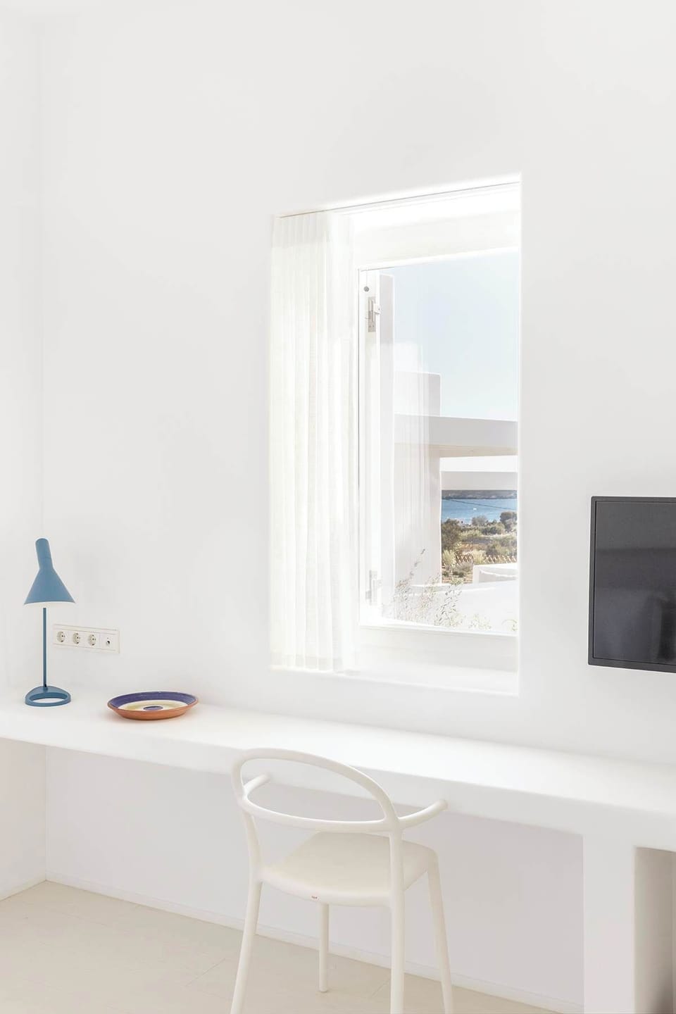 The room features a dedicated workspace overlooking the sea